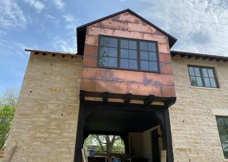 Copper metal panel facade on a stone building for Skylight Installation in Oak Island