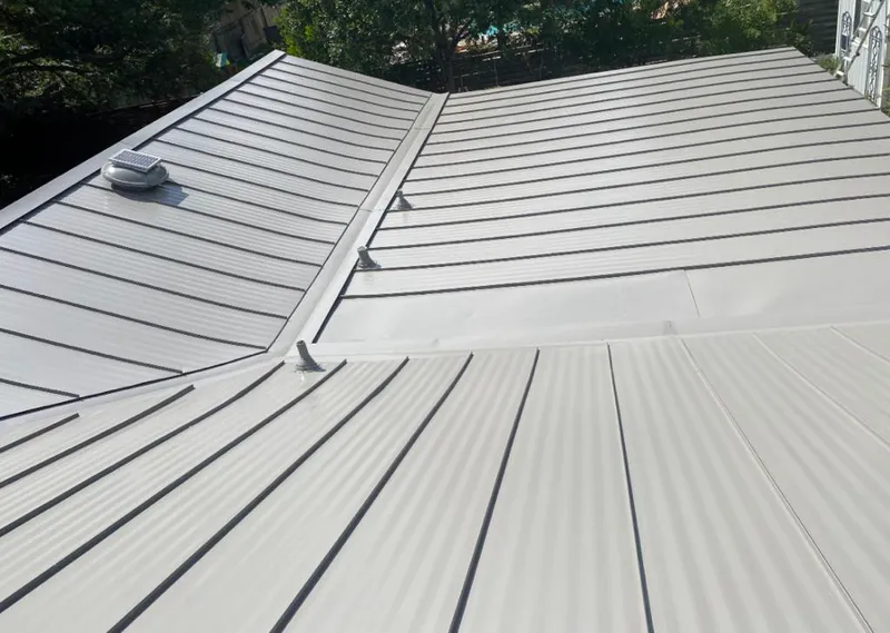 Solar attic fan installed on a metal roof for Roof Ventilation in Oak Island