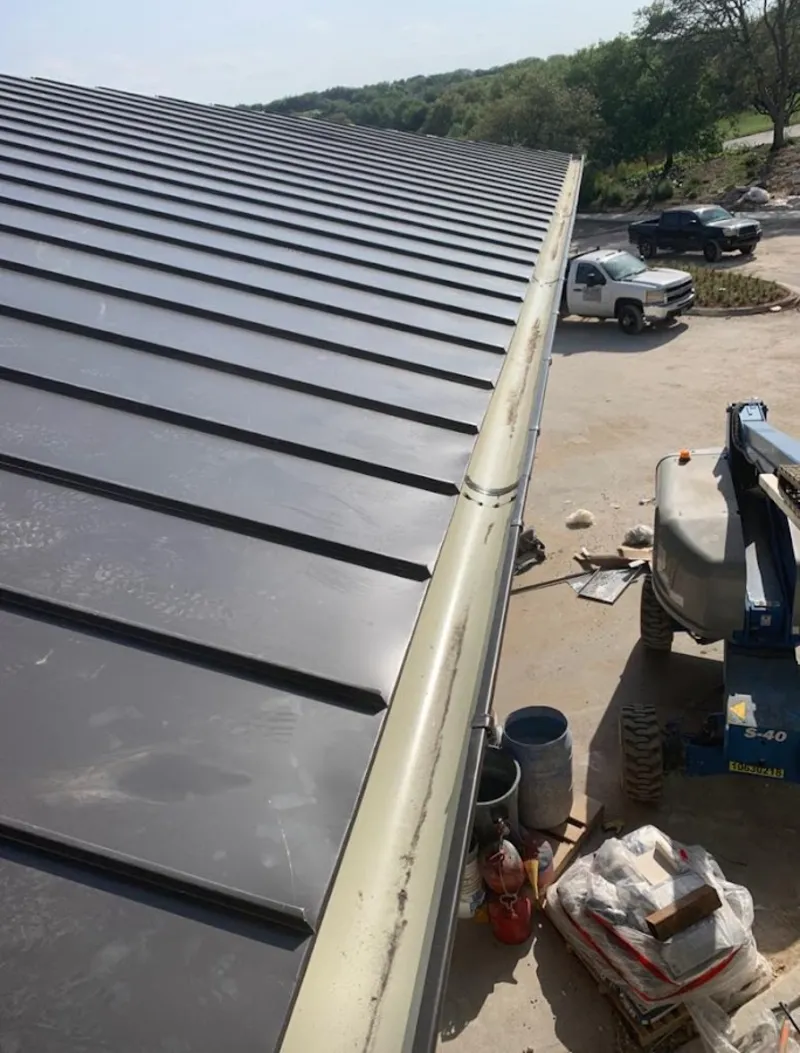 Standing seam panel and gutter detail on a metal roofing jobsite in Oak Island